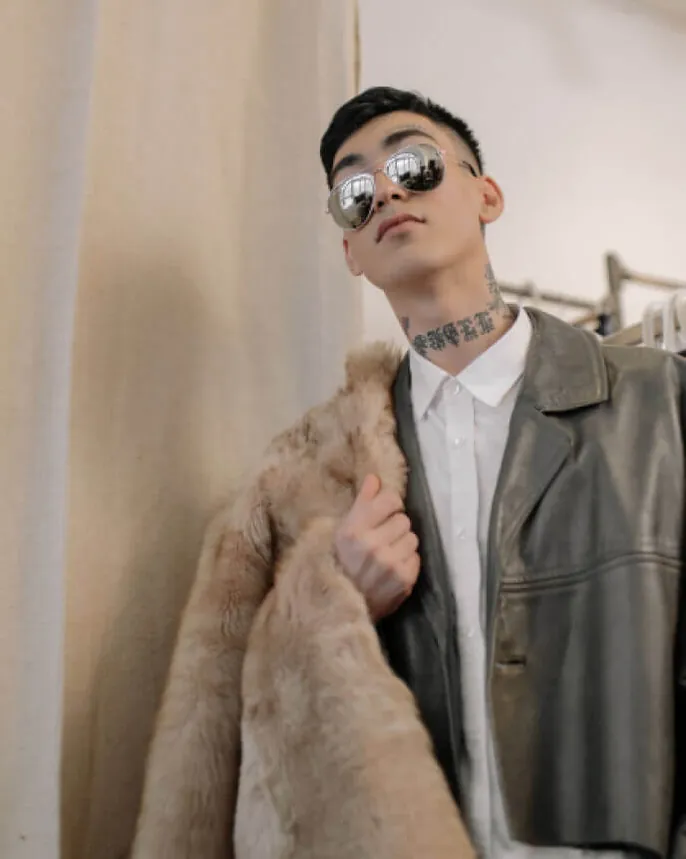 Man wearing a structured coat and leather-look accessories